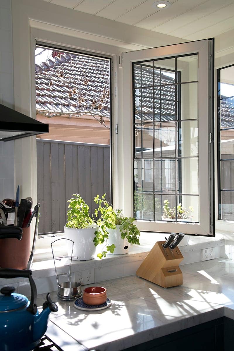 Aluminium bi-fold doors folded open from a kitchen onto the garden