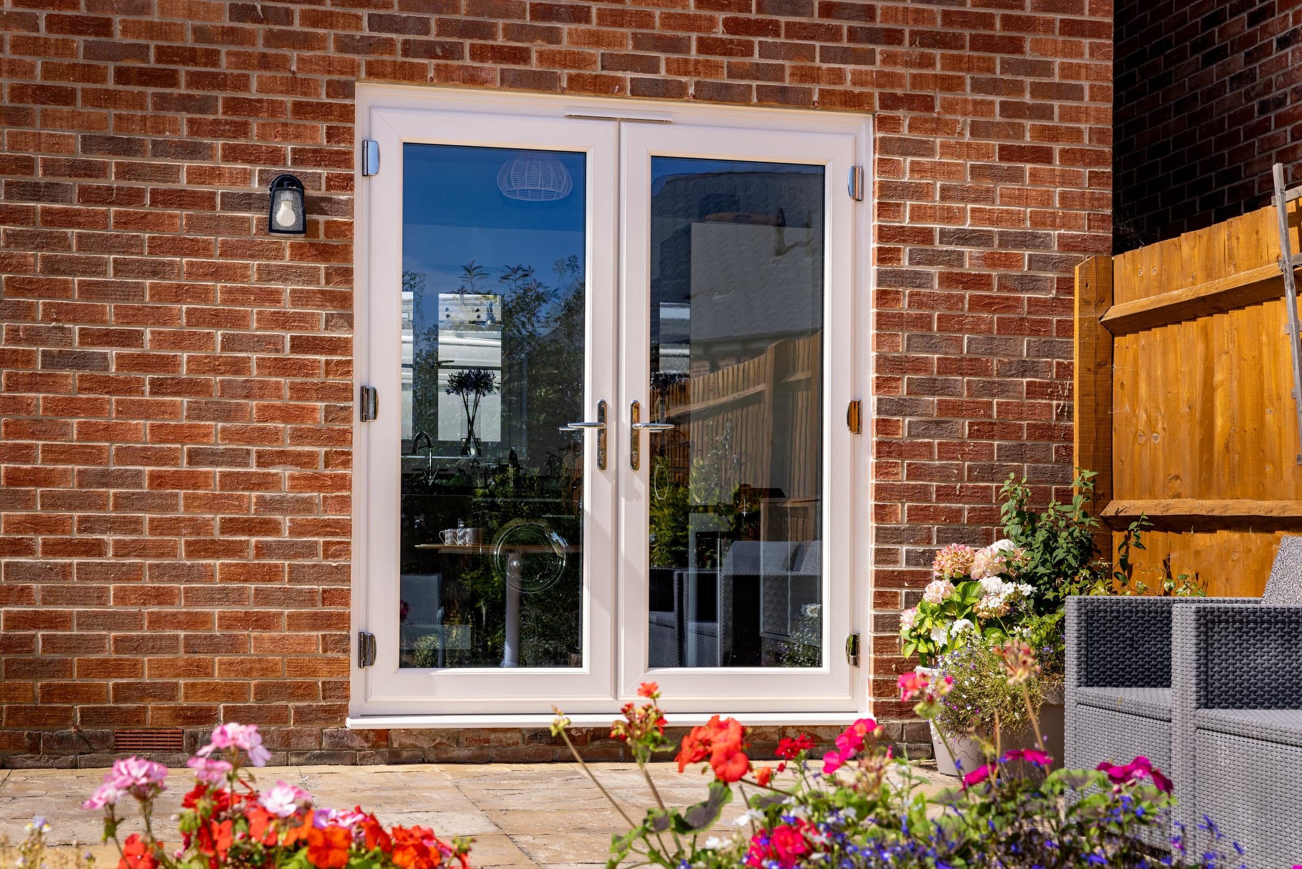 White uPVC French doors on a red-brick house