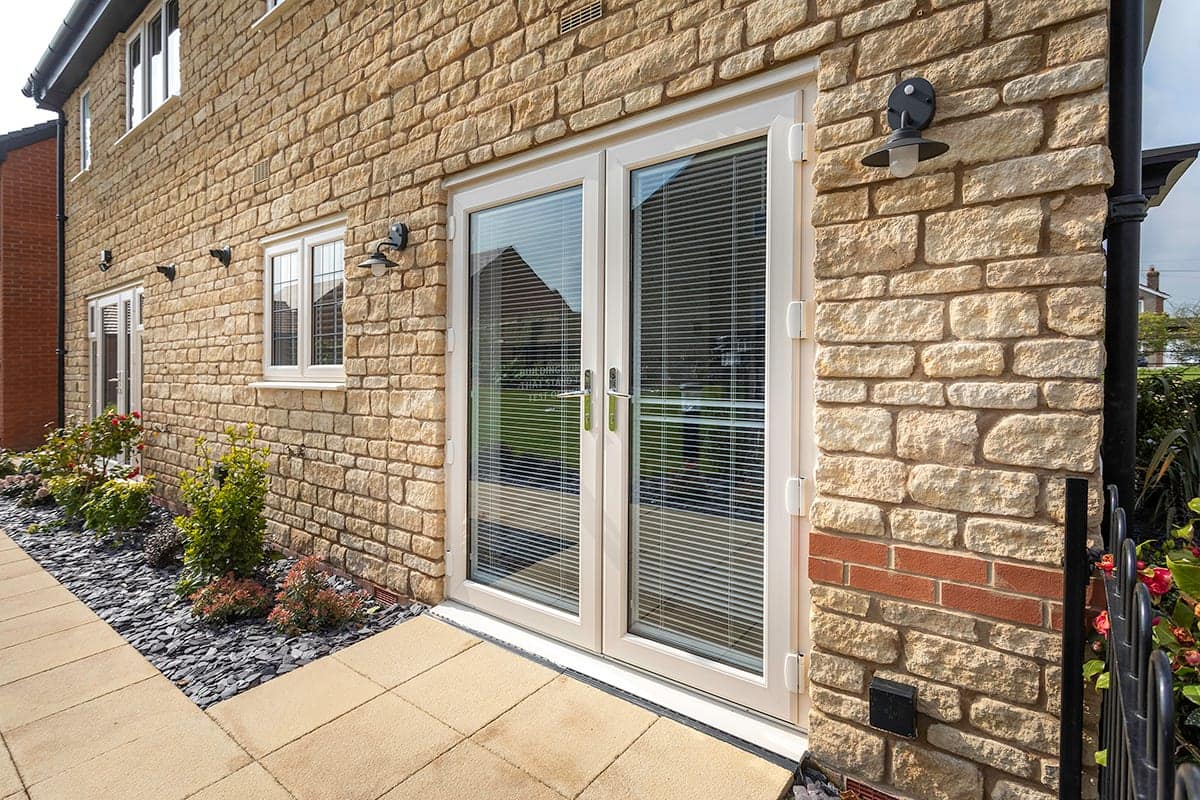 White uPVC French doors on a stone-built home
