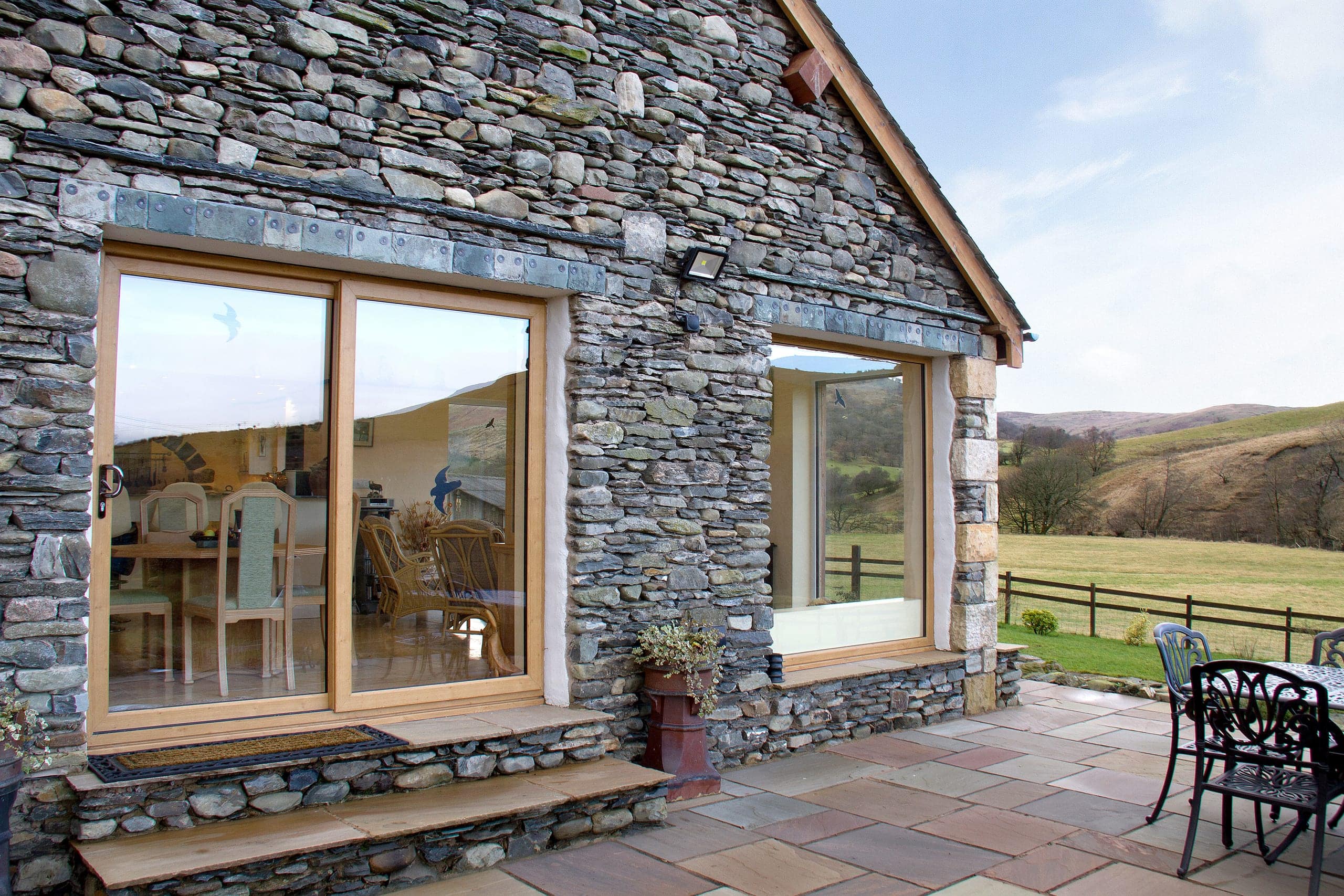 Sliding patio doors on a stone barn overlooking fields