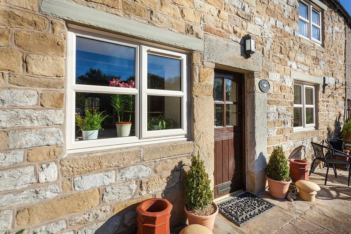 Cream uPVC windows with shutters on a cottage