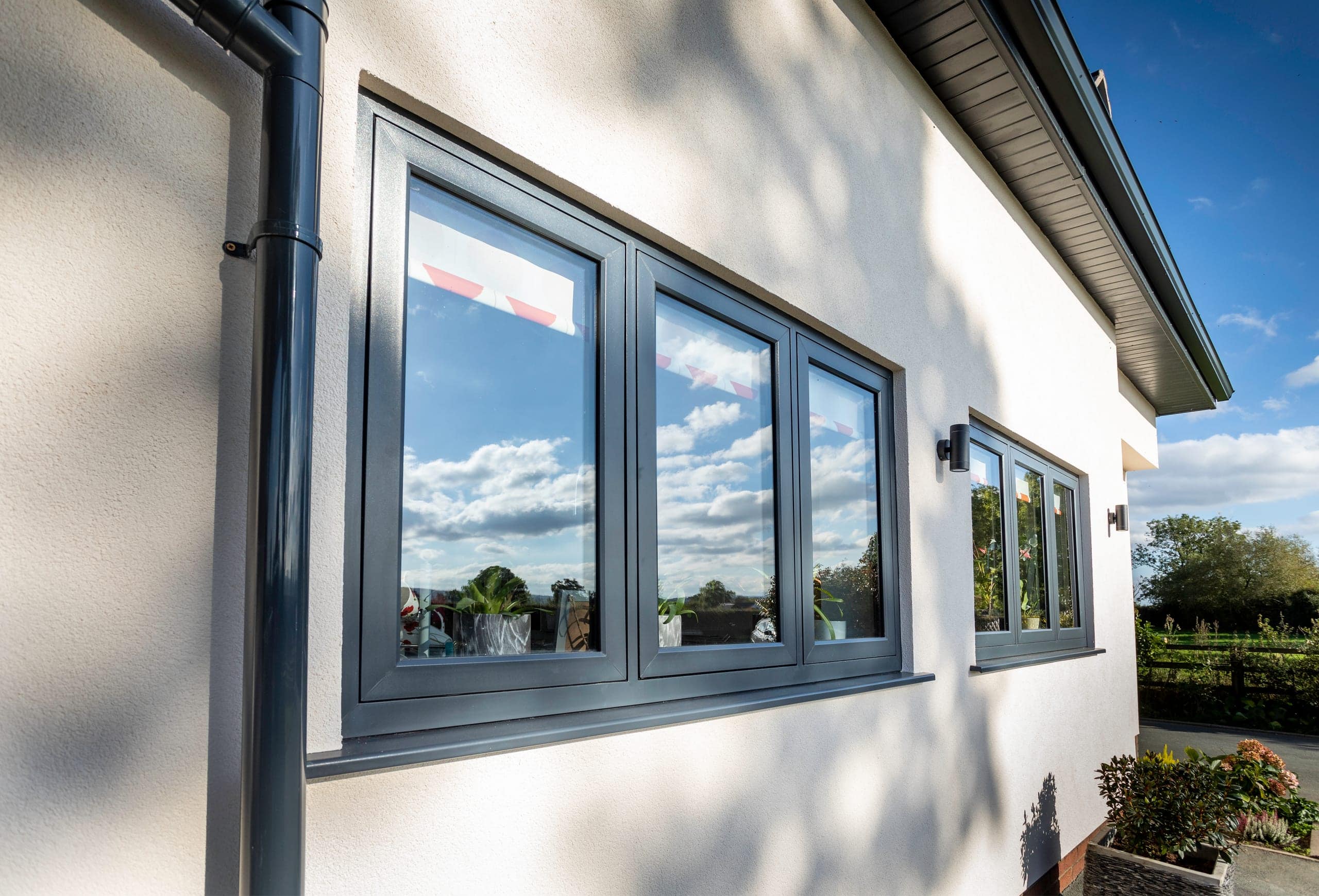 Slim grey aluminium windows on a rendered bungalow