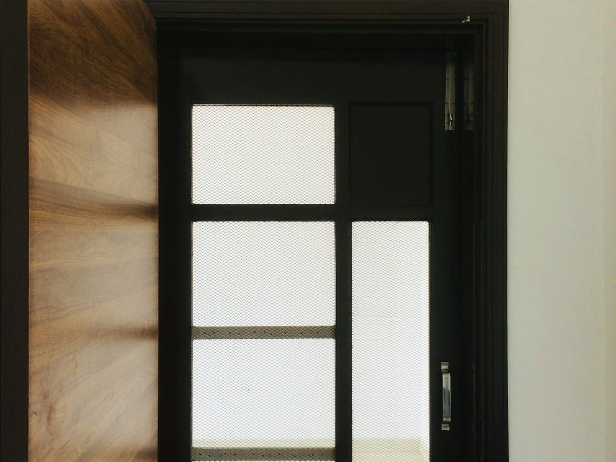 Dark-framed entrance door with frosted glass panels