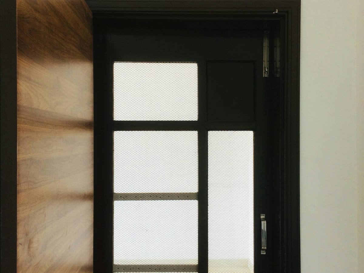 Dark-framed entrance door with frosted glass panels