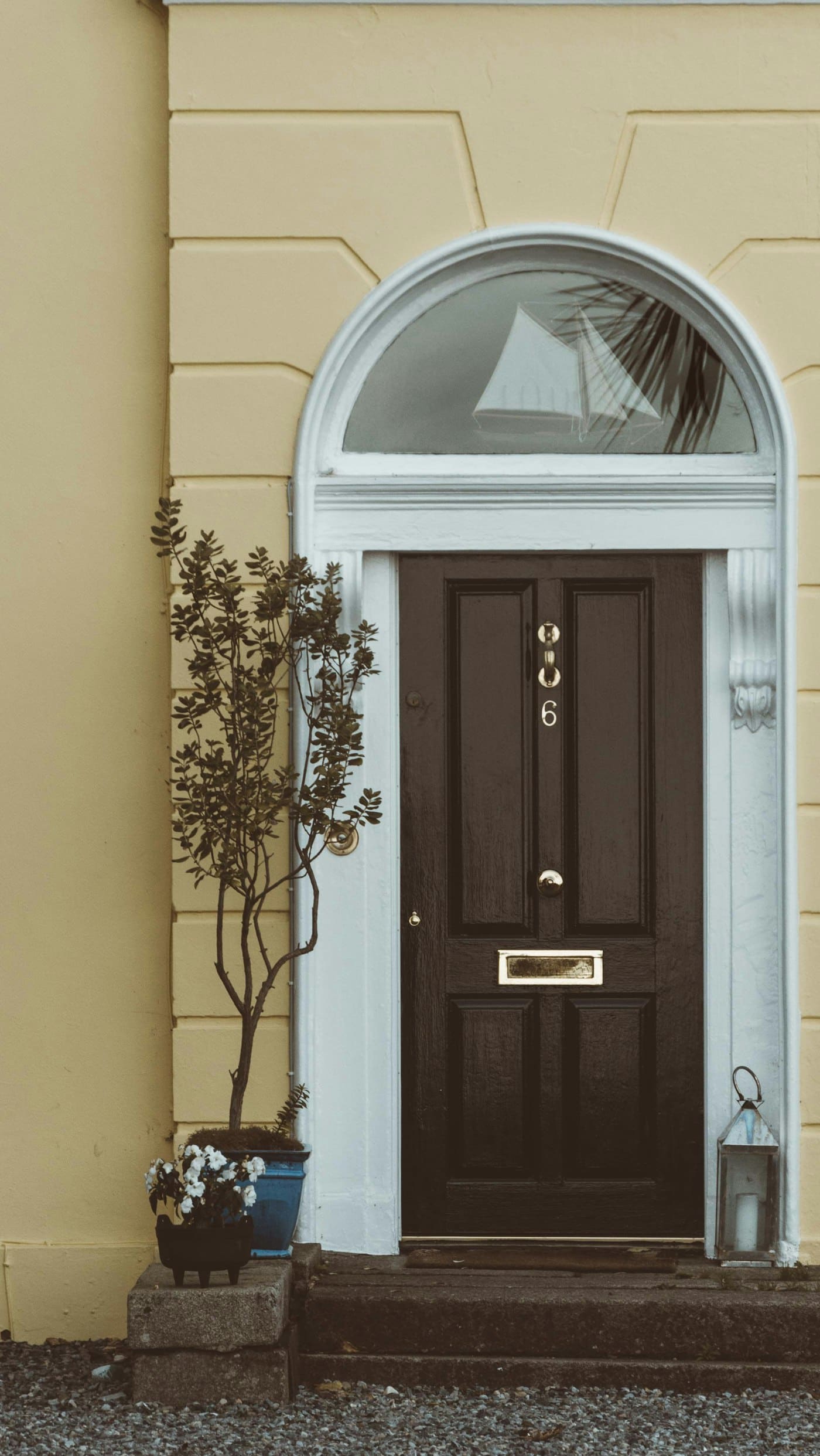 Panelled composite front door with a glazed fanlight above