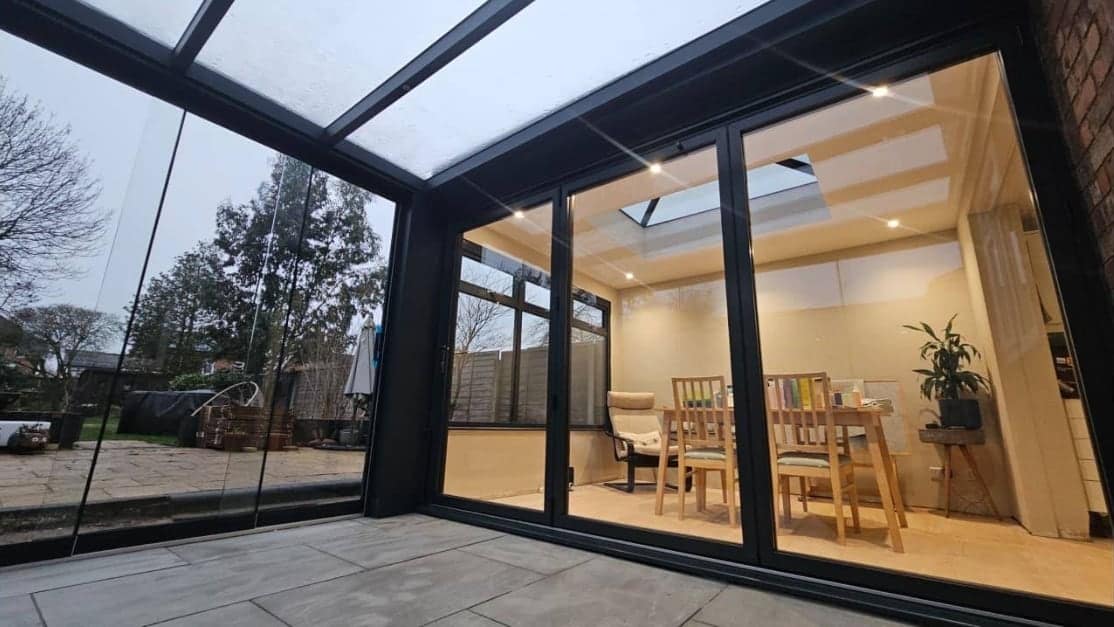 Anthracite-framed glazing and doors seen from inside a bright garden room