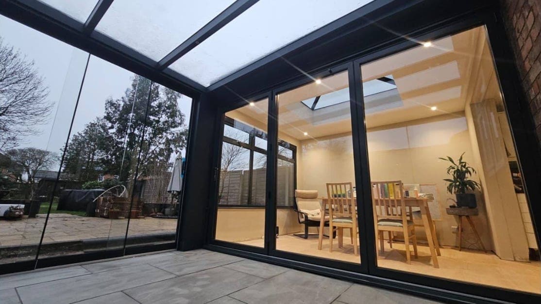 Anthracite-framed glazing and doors seen from inside a bright garden room