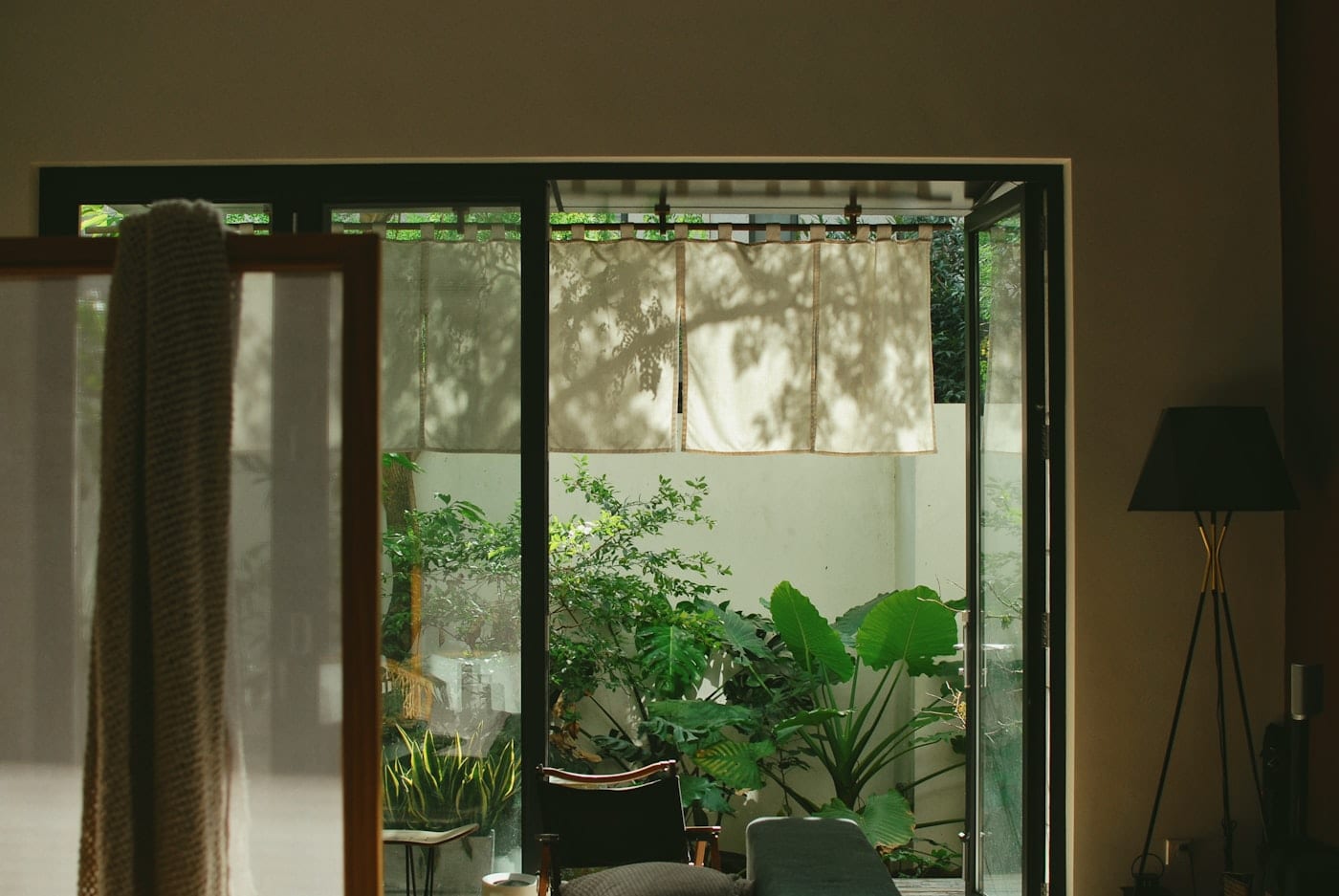 Black-framed sliding patio doors opening onto a planted courtyard