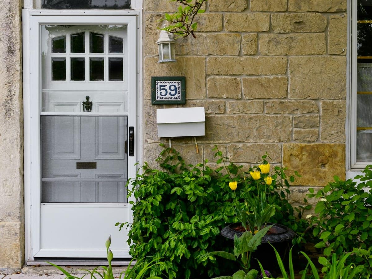 White panelled front door with glazed top panels on a stone cottage