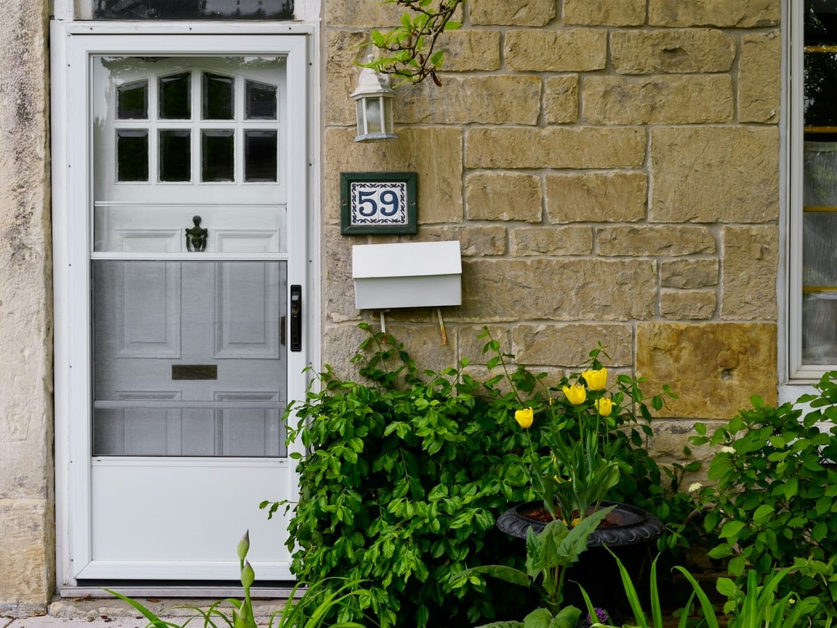 White panelled front door with glazed top panels on a stone cottage