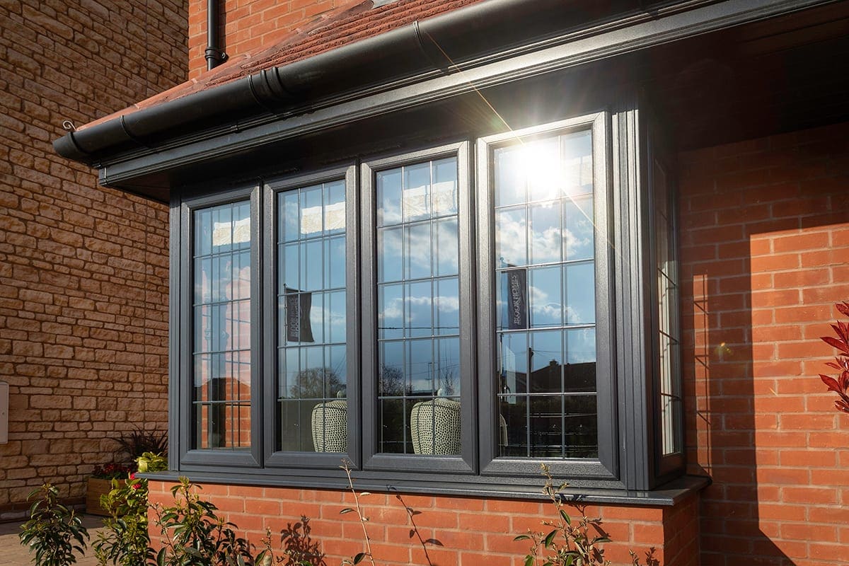 Anthracite-grey bay window on a red-brick house