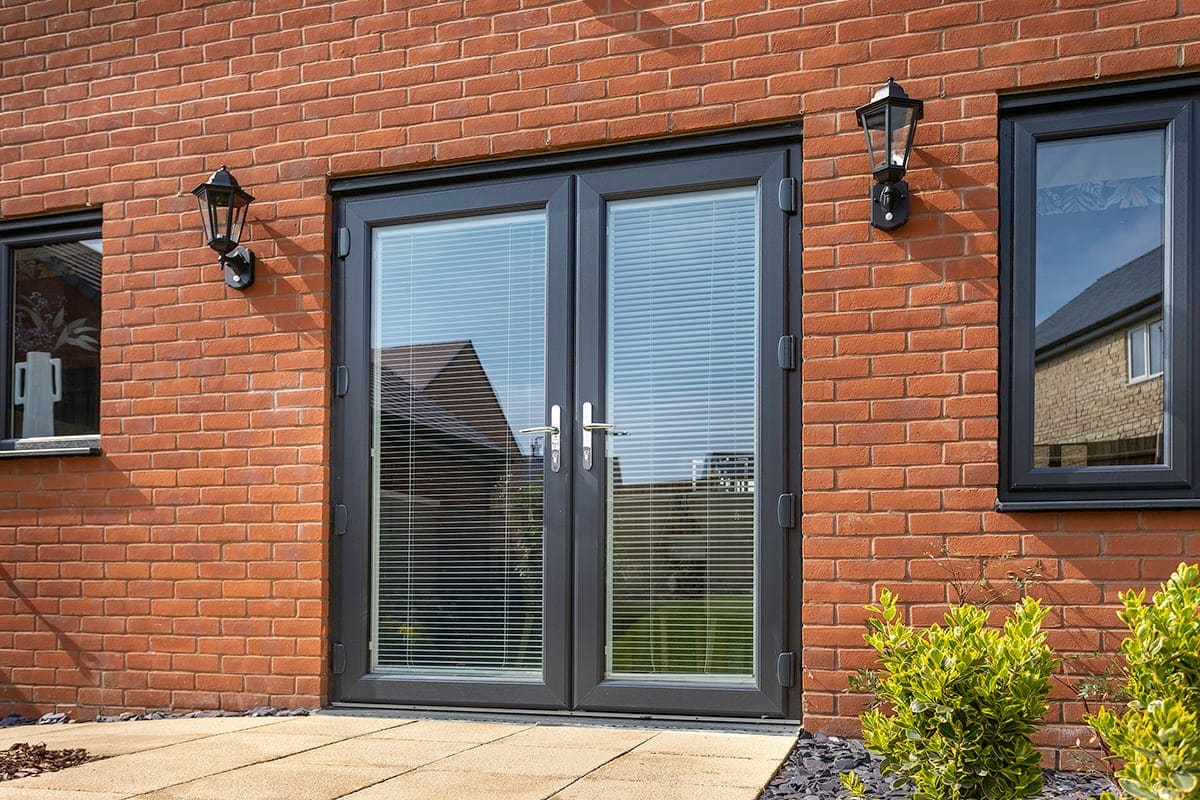 Anthracite-grey French doors on a red-brick house