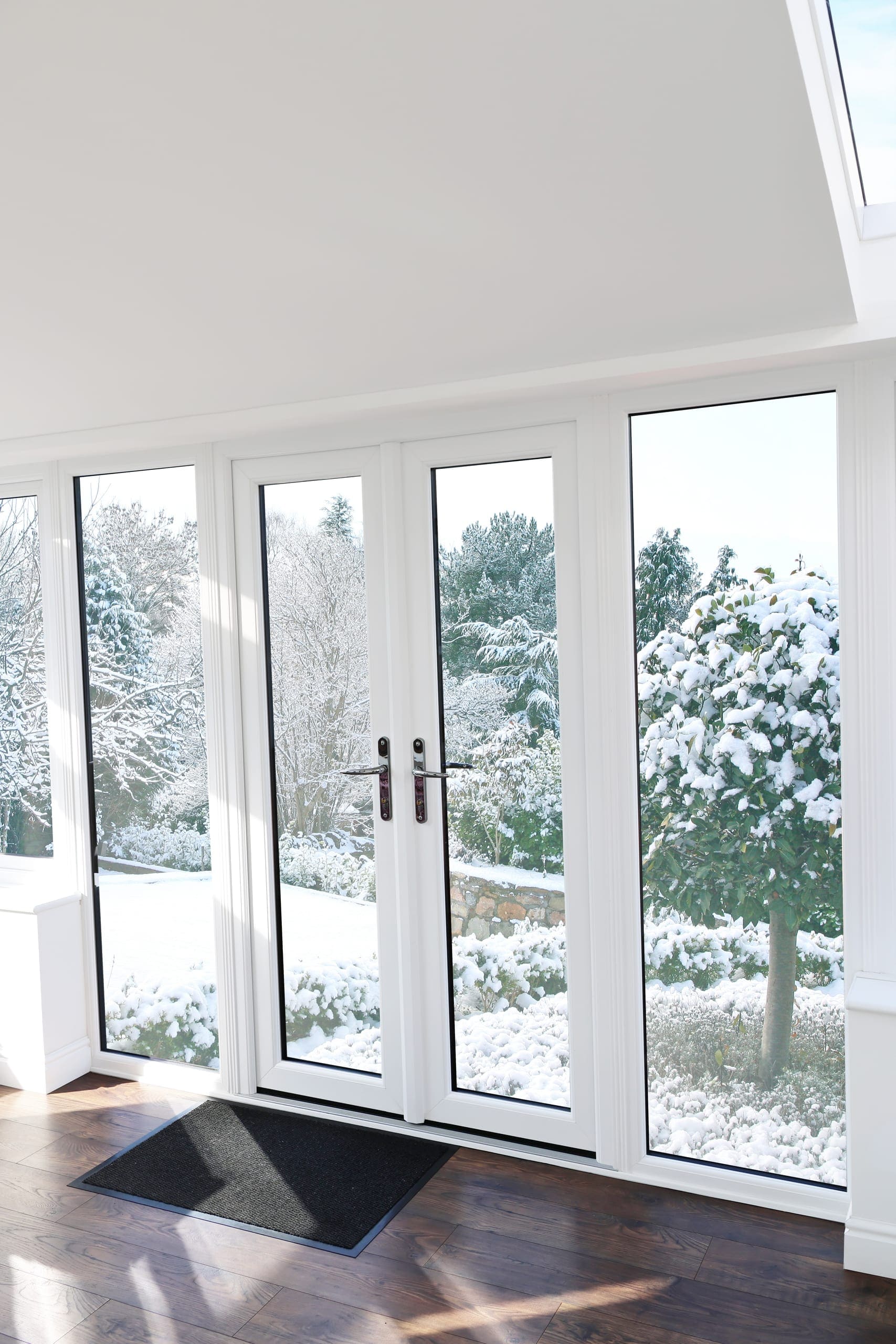 White French doors overlooking a snowy garden