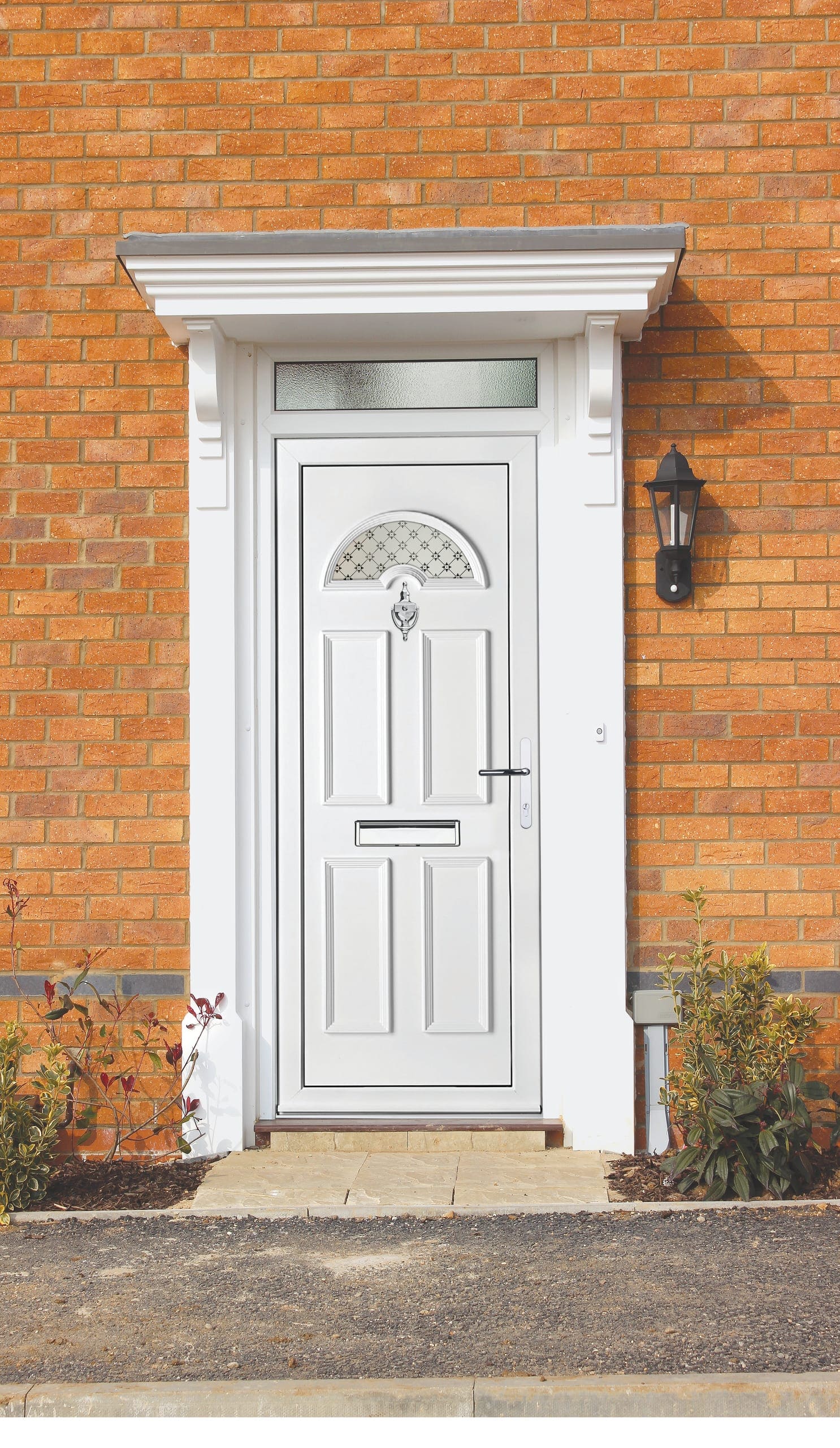 White uPVC front door with a sunburst top light on a brick house