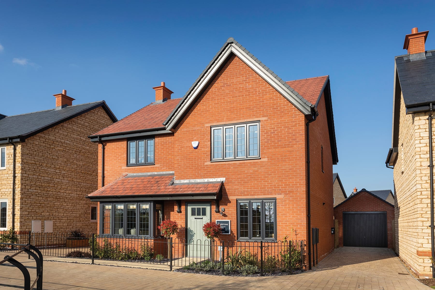 Red-brick detached home with white uPVC windows