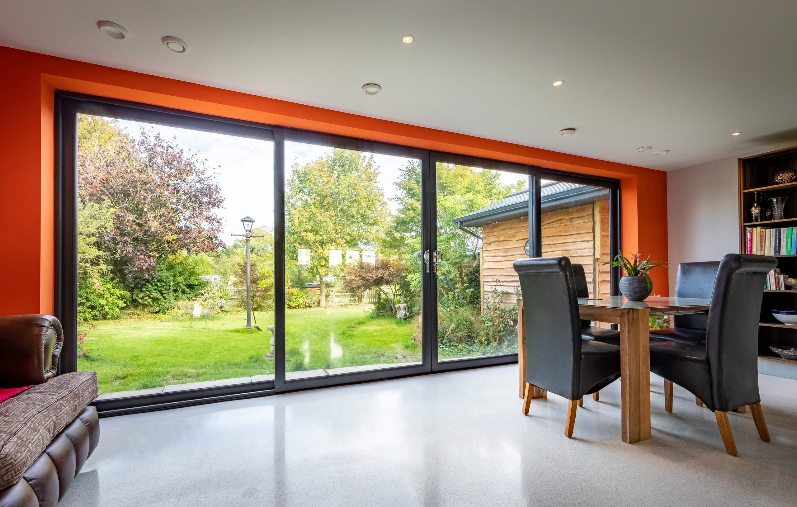 Aluminium sliding doors opening a dining room to the garden
