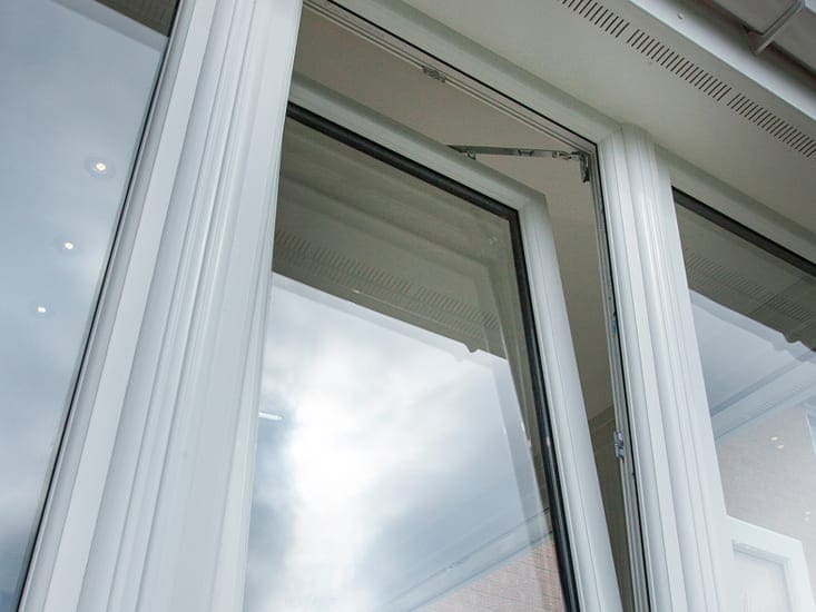 White uPVC window tilted open, seen from inside